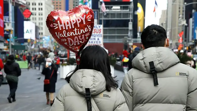 دو زوج عاشق در حال راه رفتن در خیابانی که به مناسبت ولنتاین تزئیین شده است